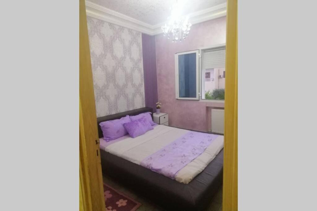 a bedroom with a bed with purple pillows at Beautiful appartment with a glorious sea view in Monastir