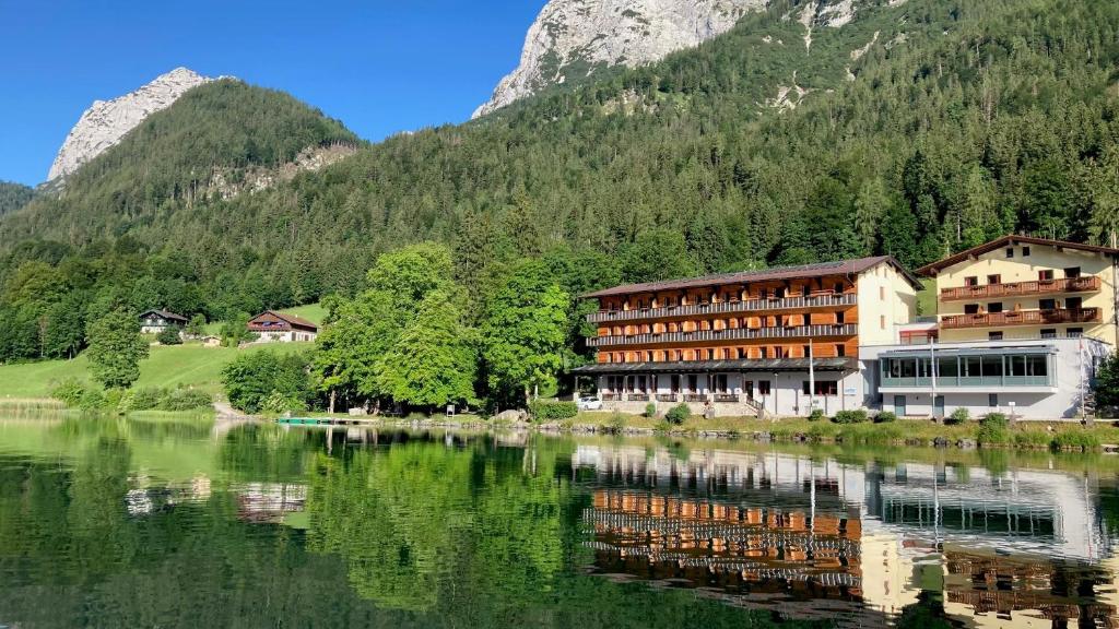 un hotel junto a un lago con montañas en el fondo en ALPEN EXPERIENCE Jugendgästehaus en Ramsau