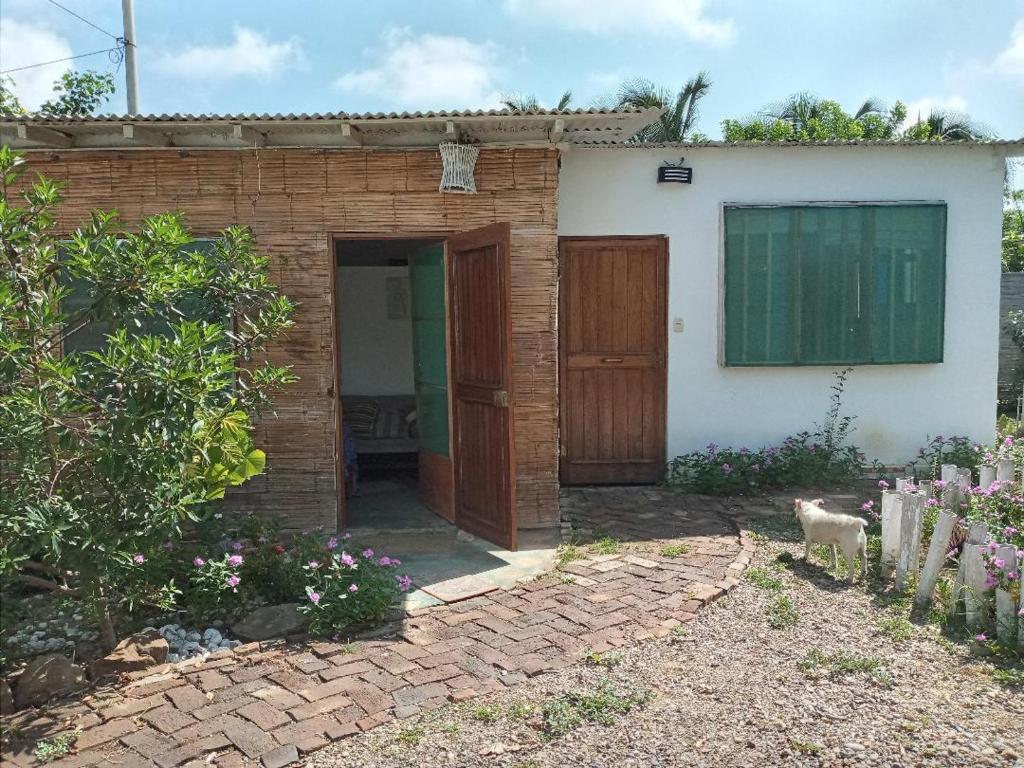 een stenen huis met een deur en een tuin bij LA CABAÑA DE HUERTAMAR in Zorritos