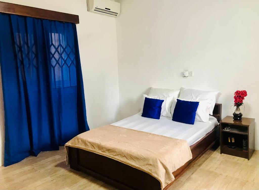 a bedroom with a bed with blue curtains and a window at Moroccan Tile House - Tranquil Estate - Boundary Rd in Madina