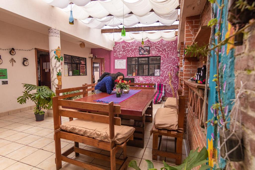 een vrouw aan een tafel in een restaurant bij Hostel Mirador in San Cristóbal de Las Casas