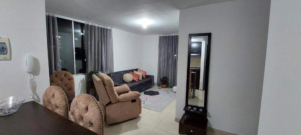 a living room with two chairs and a couch at Arturo Apartamento Con hermosa vista y piscina in Armenia