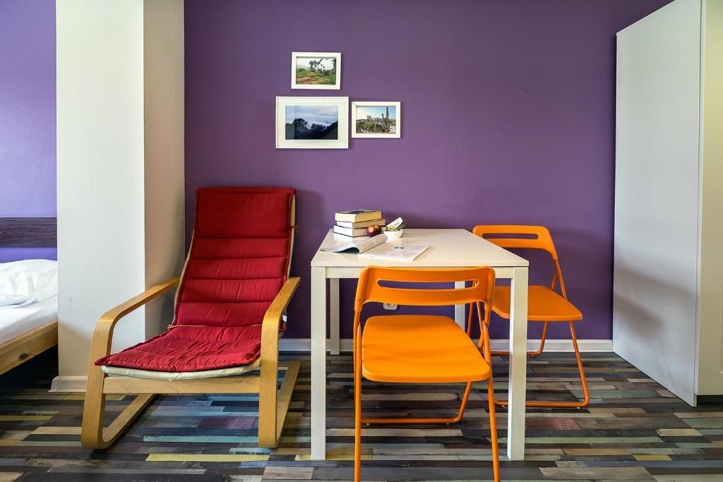 ビェルスコ・ビャワにあるHello Hostel & Apartmentsの紫の壁の部屋(テーブル、椅子付)