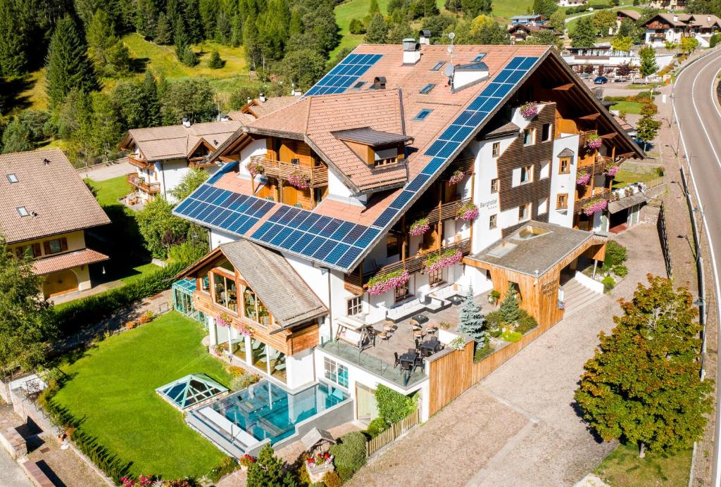 an aerial view of a house with solar panels on the roof at Berghotel Miramonti in Tesero