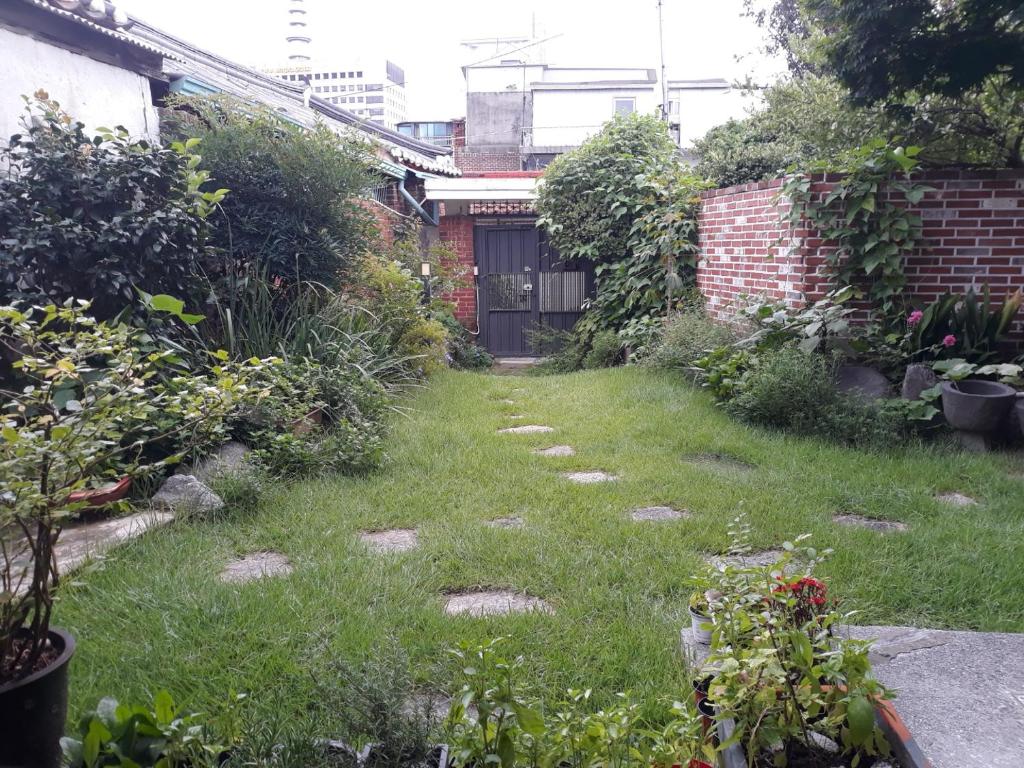 a garden with a lawn with rocks in the grass at Hans House in Seoul