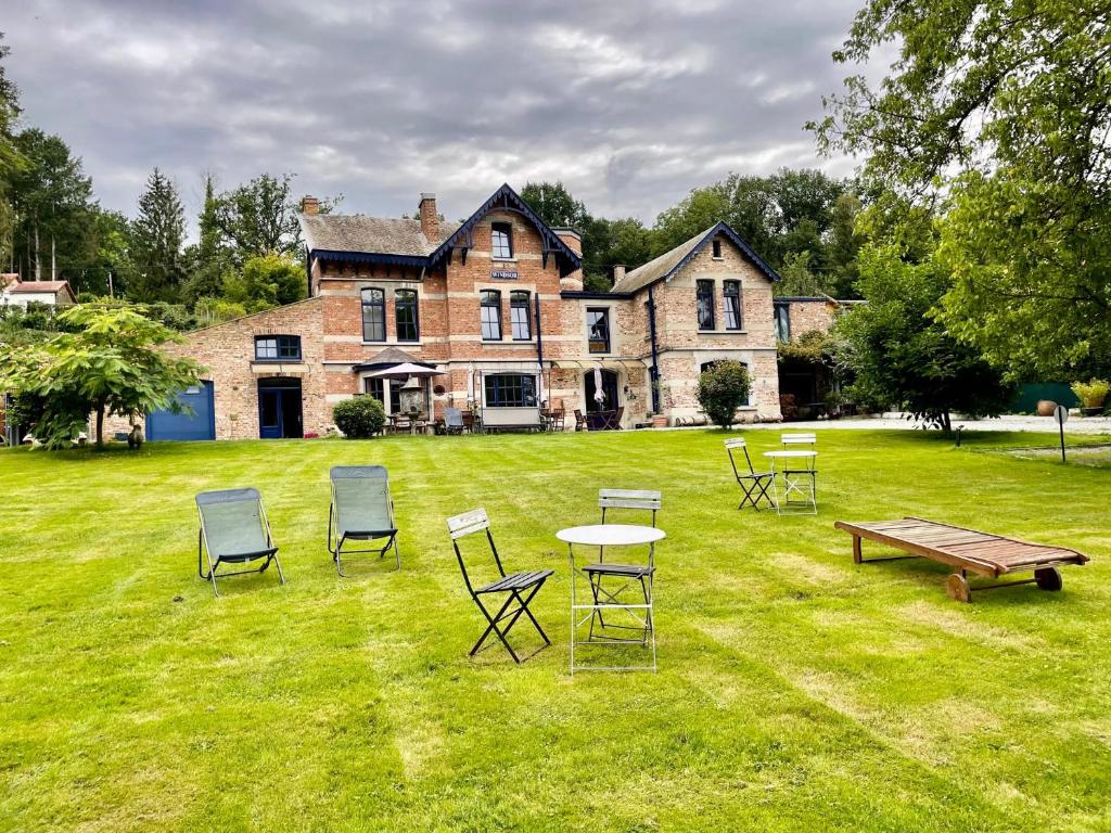 a group of chairs and tables in front of a house at B&B Windsor - Guesthouse in Waulsort