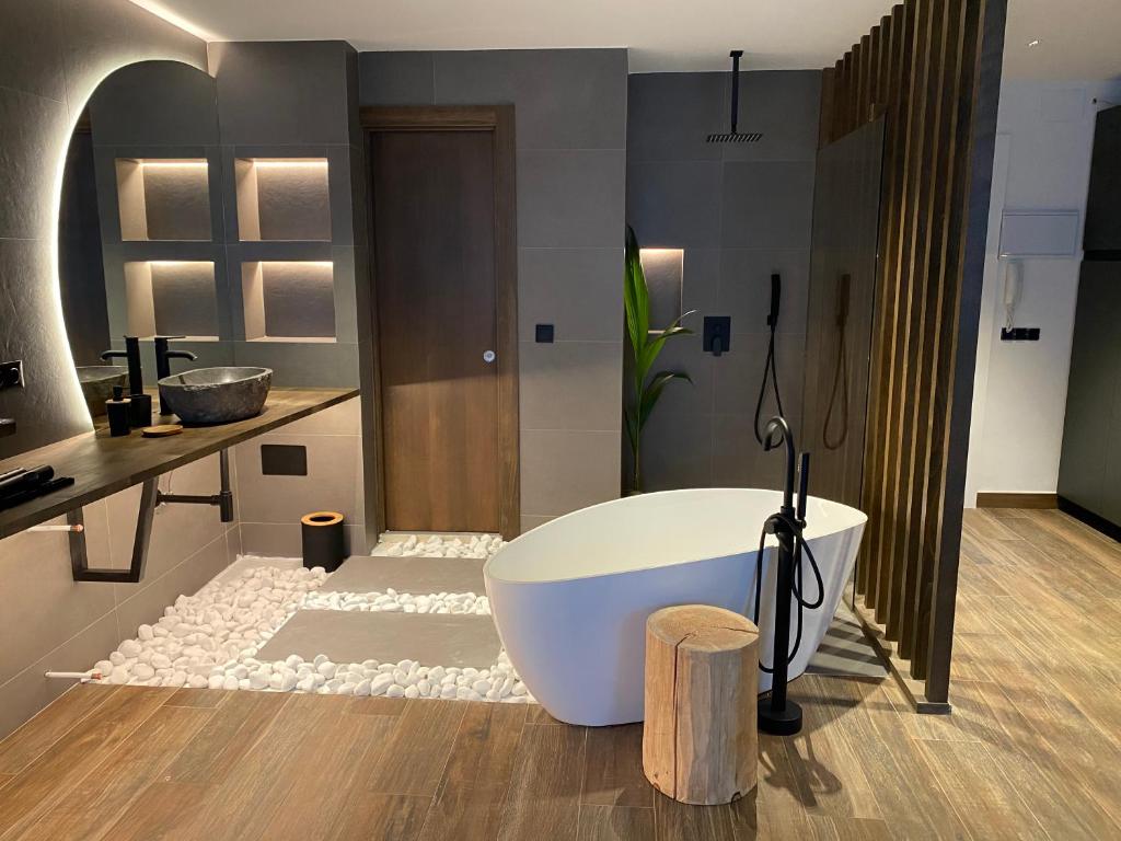 a bathroom with a white tub and a sink at Botavara Madrid con Parking incluido in Madrid