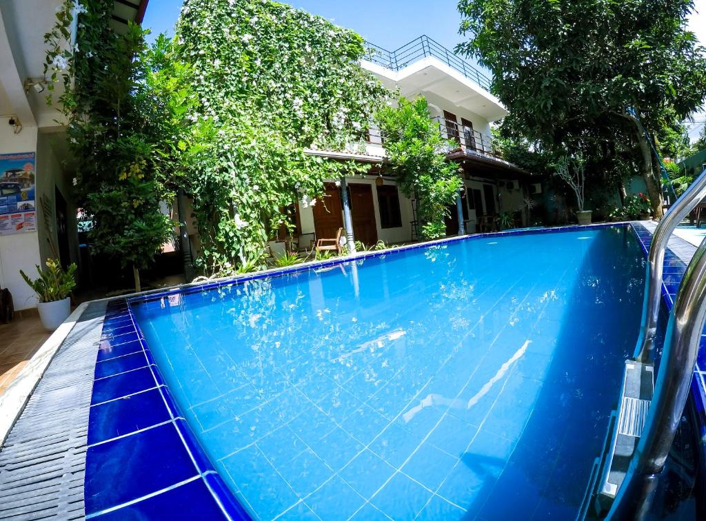 a large blue swimming pool in front of a house at Mirissa Blue Whale Holiday Hotel in Mirissa