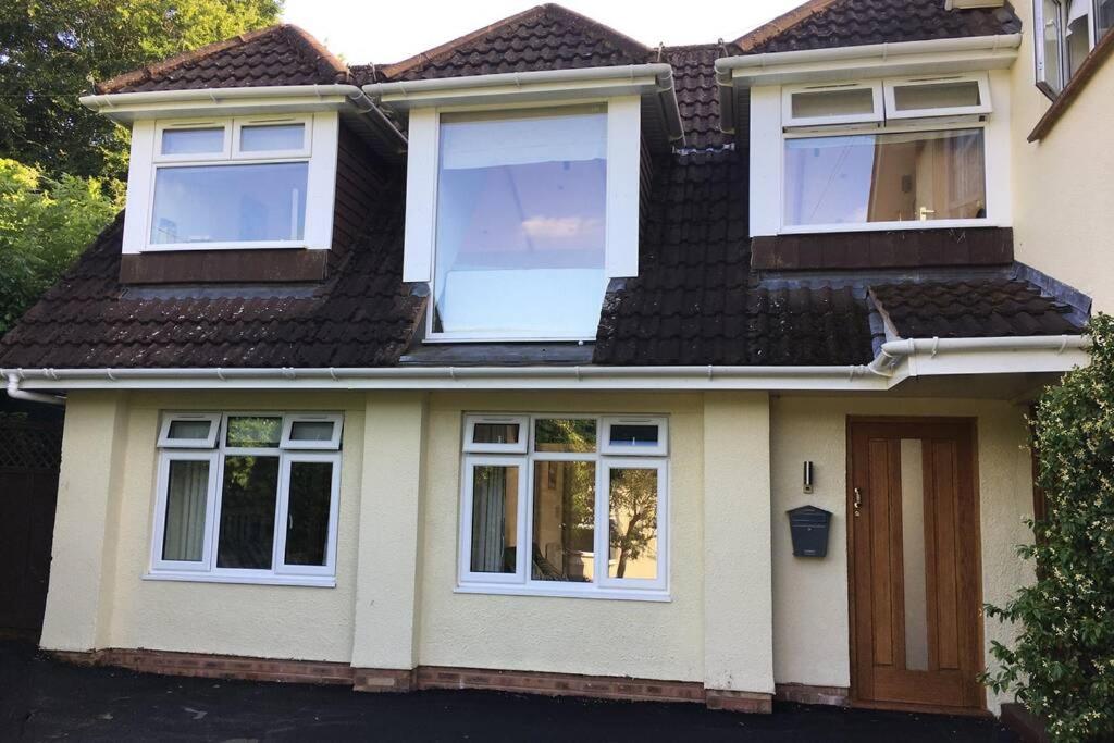 a house with white windows and a brown door at Lovely ground floor apartment in quiet village in Exeter