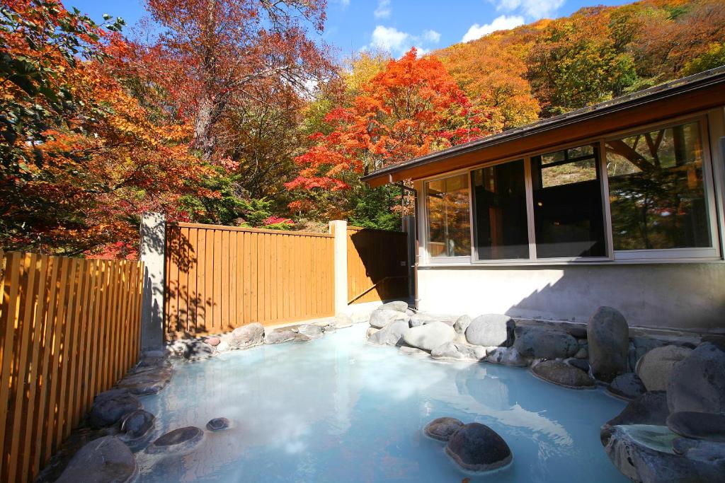 a pool of water next to a house at Chuzenji Kanaya Hotel in Nikko