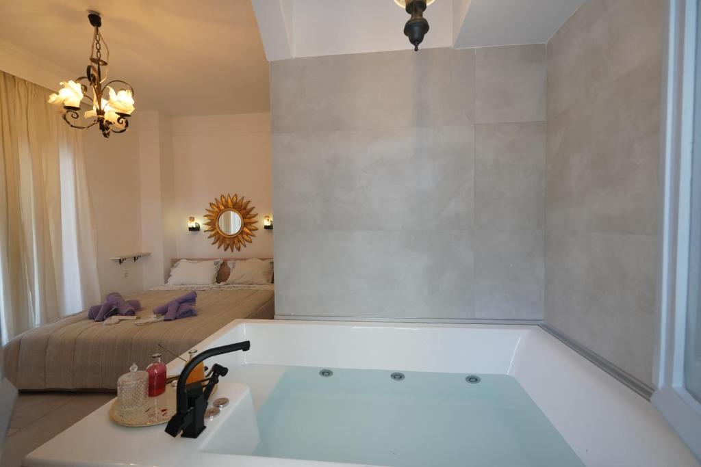 La salle de bains est pourvue d'une baignoire et d'un lit. dans l'établissement "Del Sole" Spa Apartment, à Serres