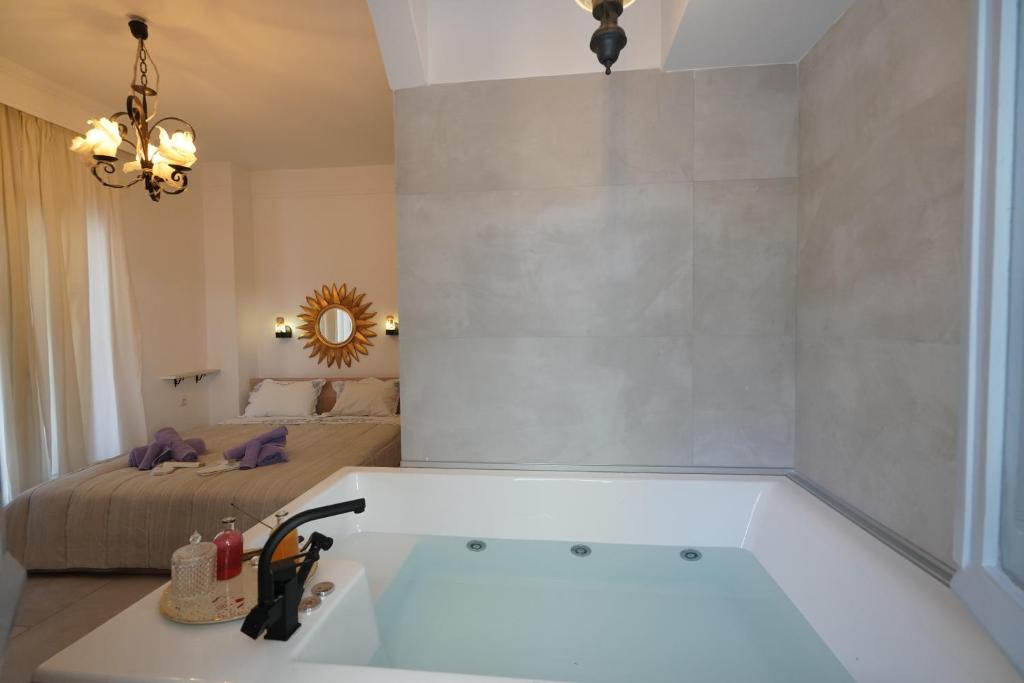 a bathroom with a bath tub and a bed at "Del Sole" Spa Apartment in Serres