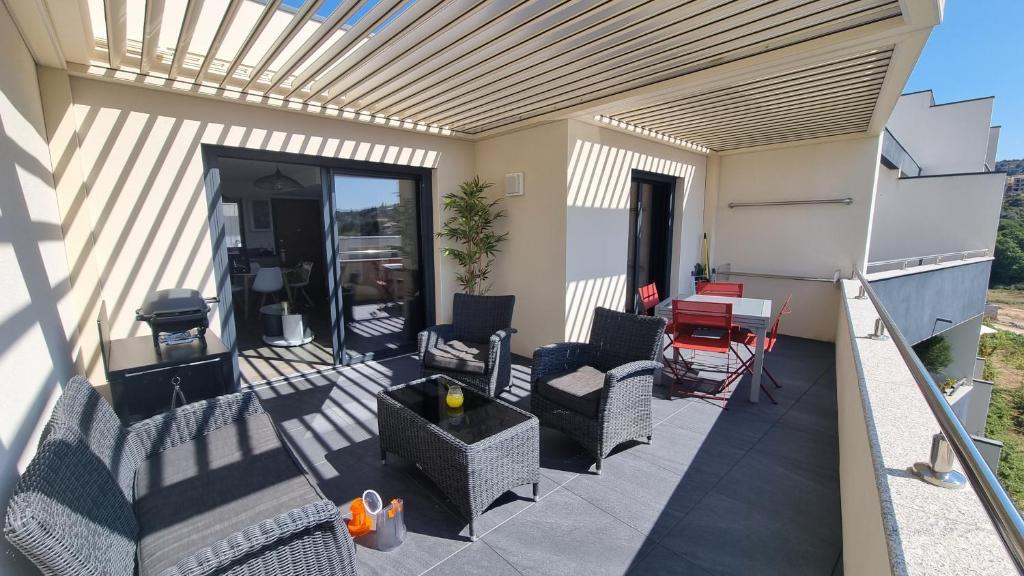eine Terrasse mit Stühlen, einem Tisch und einem Grill in der Unterkunft Appartement neuf T2 centre de Porticcio in Porticcio