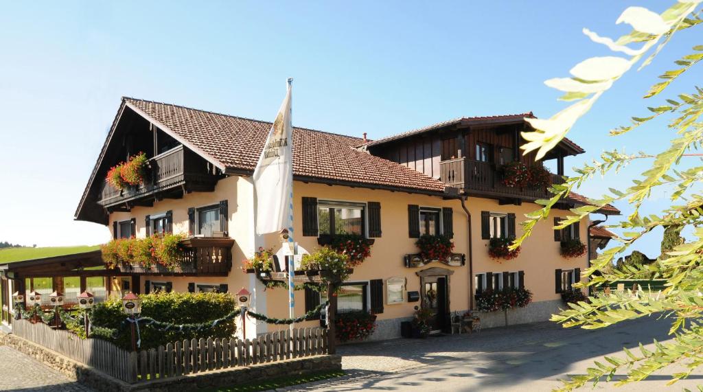 a large building with flower boxes and a fence at Pension Leithenwald in Zwiesel