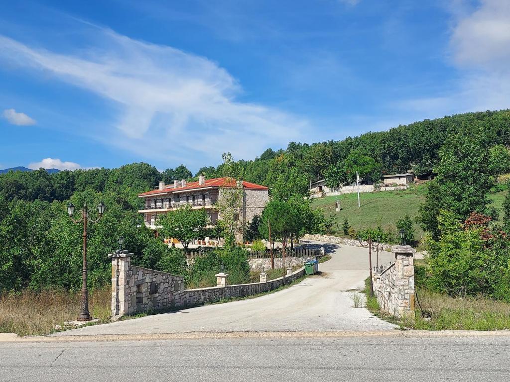 une maison au sommet d'une colline avec une route dans l'établissement Miaritis rooms, à Kryonérion