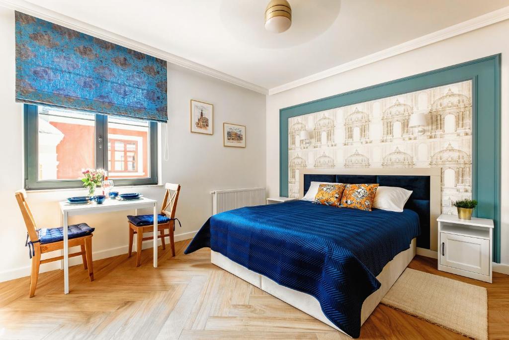 a bedroom with a blue bed and a desk at Apartamenty na Roztoczu - Apartament Szafirowy in Zamość