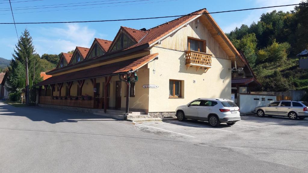 a white car parked in front of a building at Penzión pri studničke Omastiná in Omastiná