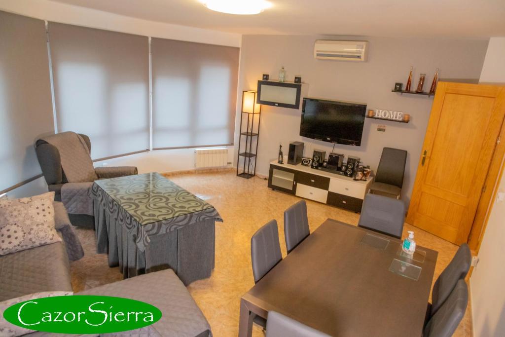 - un salon avec un canapé, une table et une télévision dans l'établissement CazorSierra, bonita vivienda en Cazorla, à Cazorla