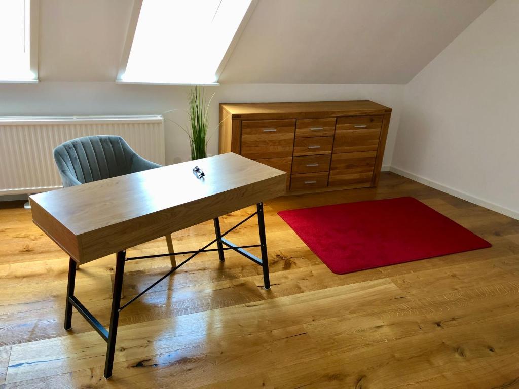 Zimmer mit einem Schreibtisch, einem Stuhl und einer Kommode in der Unterkunft Studio in der Celler Altstadt in Celle