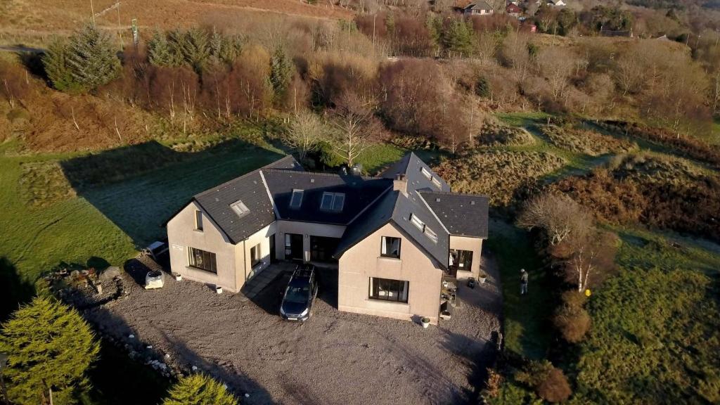 a large white house with a black roof at Arisaig Holiday Apartment in Arisaig