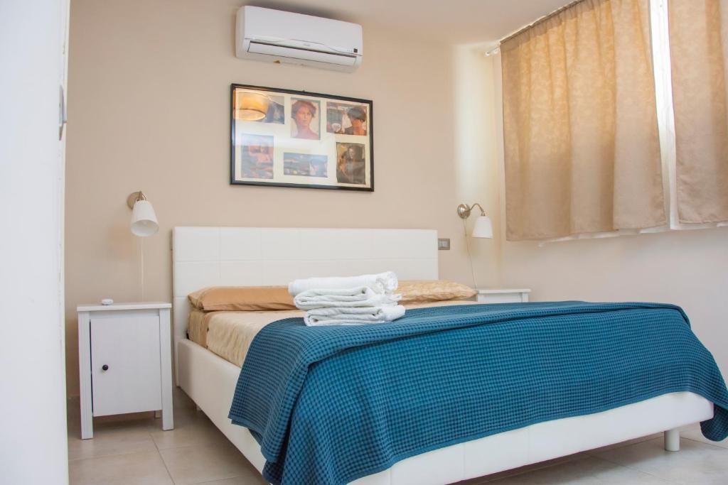 シポントにあるB&B Domus del Soleのベッドルーム1室(青い毛布付きのベッド1台付)