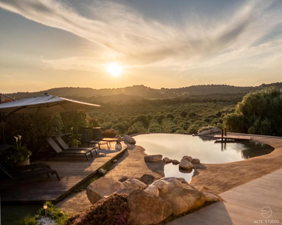 einen Pool mit Sonnenuntergang im Hintergrund in der Unterkunft Casa Lagone - Villa Luxe avec Piscine et Superbe Vue in Cargèse