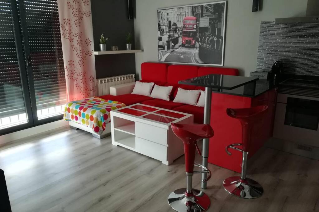 a living room with a red couch and a table at Apartamento en ribeira sacra. Chantada in Chantada