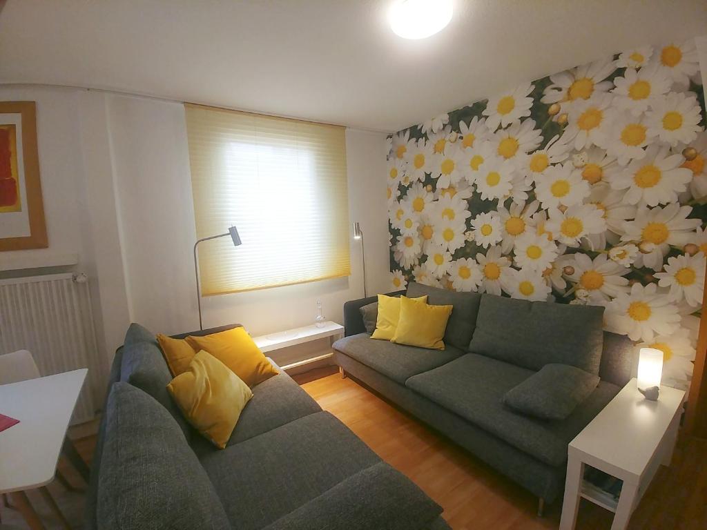 a living room with a couch and a flower wall at Ferienwohnung Rheinblick Koblenz in Koblenz