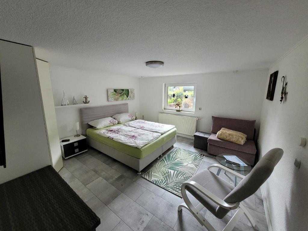 ein kleines Schlafzimmer mit einem Bett und einem Sofa in der Unterkunft Fewo Moin Moin in Groß Petershagen