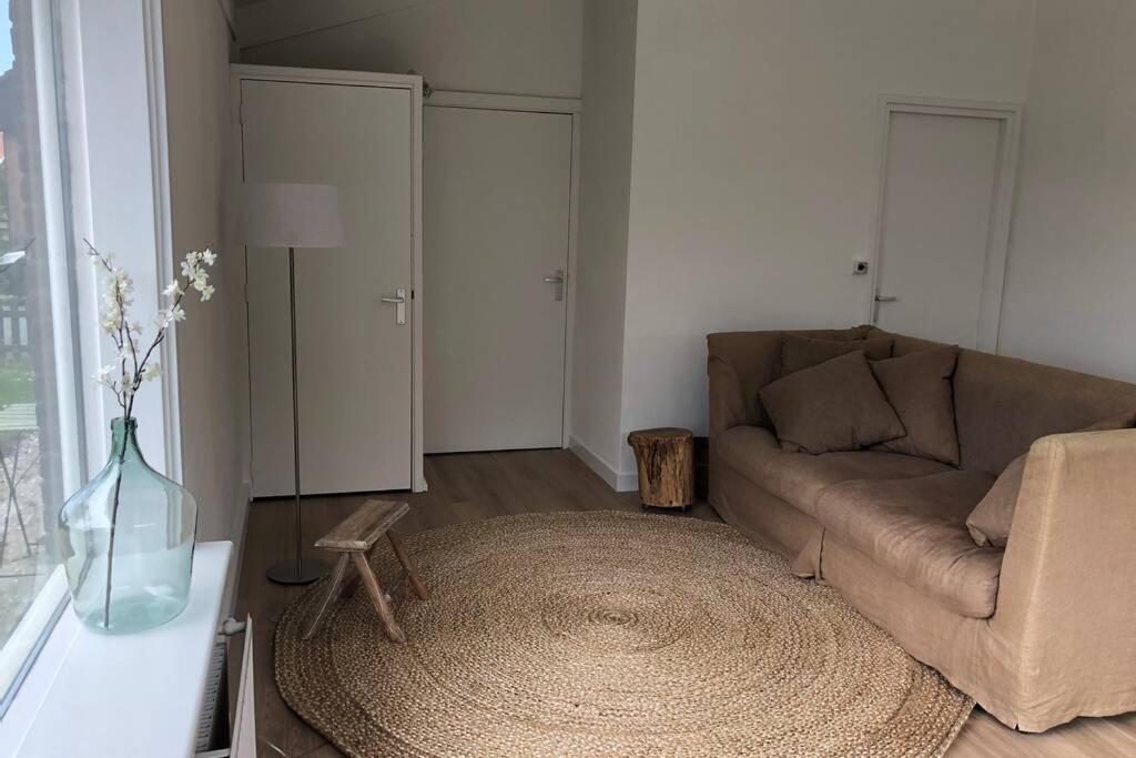 een woonkamer met een bank en een tafel bij Kust-, fiets-, wandel-, rust- & cultuurlocatie in Castricum