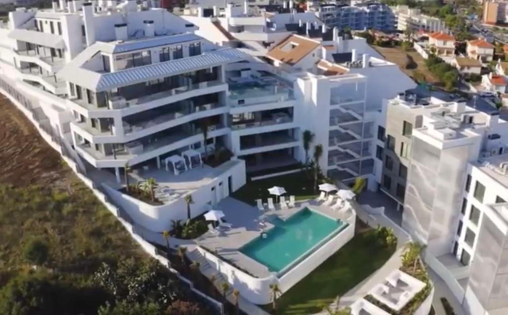 - une vue aérienne sur un grand bâtiment blanc doté d'une piscine dans l'établissement Luxury Penthouse Jacobo - The View Fuengirola, à Fuengirola
