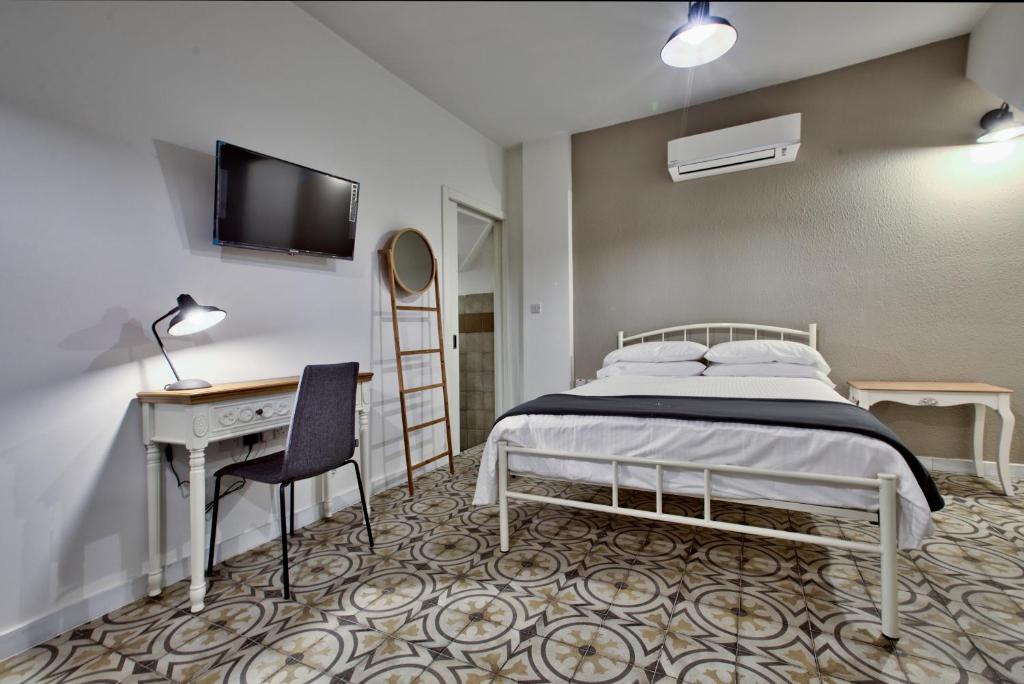 - une chambre avec un lit, un bureau et une télévision dans l'établissement Chateau La Vallette - Barrakka Suite, à La Valette