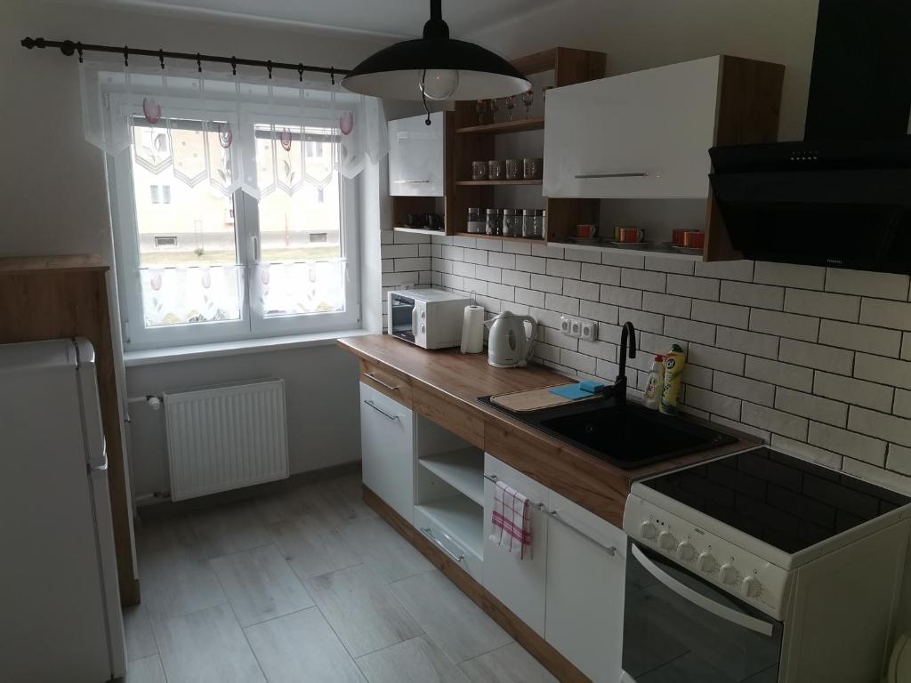 a kitchen with a counter and a sink and a window at Flat in the Heart of Liptovsky Mikulas in Liptovský Mikuláš