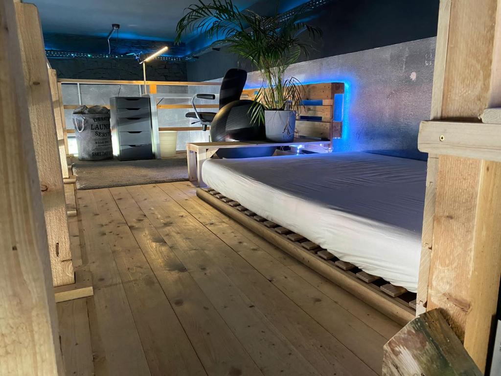 Schlafzimmer mit einem Bett mit blauem Licht in der Unterkunft Jonnys Loft in Osnabrück
