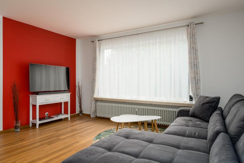 Il comprend un salon doté d'un canapé et d'une télévision à écran plat. dans l'établissement FREE LIVING - Bio-Küche - Parkplatz - 4 Gäste - Natur- Büro, à Leiferde