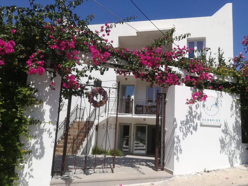 a white building with pink flowers on it at Scorpios Hotel & Suites in Samos