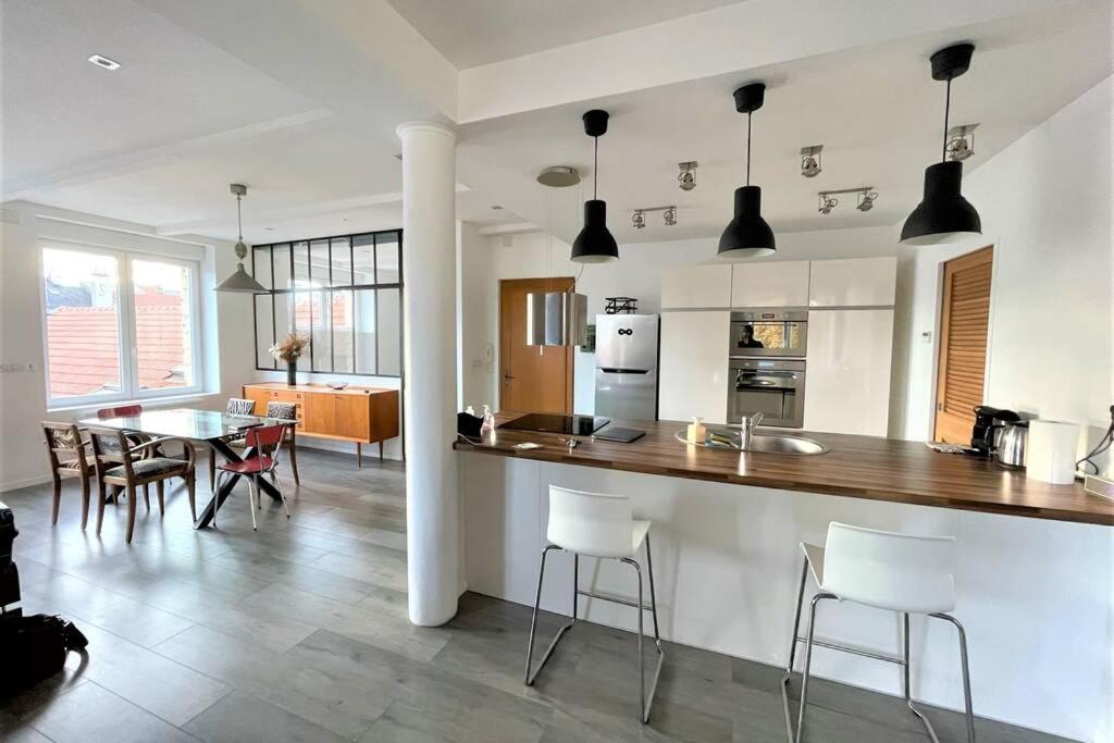 une cuisine et une salle à manger avec une table et des chaises dans l'établissement Superbe Loft 100m2 Proche Cathédrale avec Parking, à Reims