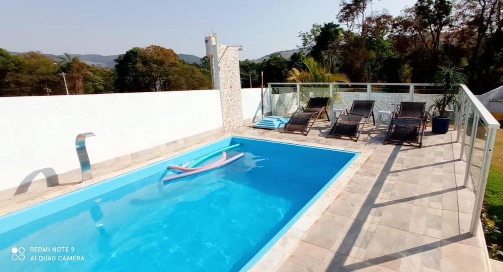 uma piscina com duas cadeiras e uma piscina em Pousada Paraíso das Águas Capitólio em Capitólio