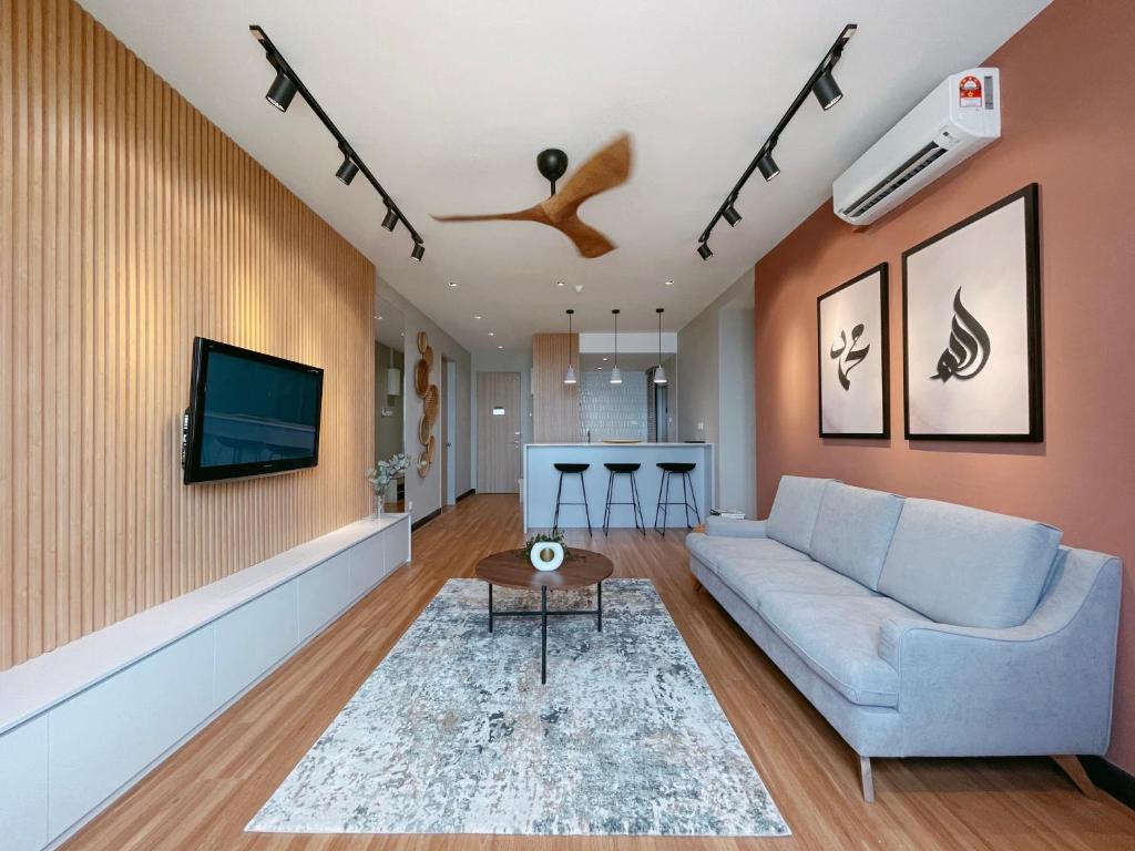 a living room with a couch and a tv at SURAI Homes in Kuala Terengganu