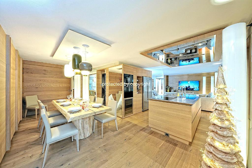a kitchen and dining room with a table and chairs at Campiglio Luxury Apartment with SPA in Madonna di Campiglio