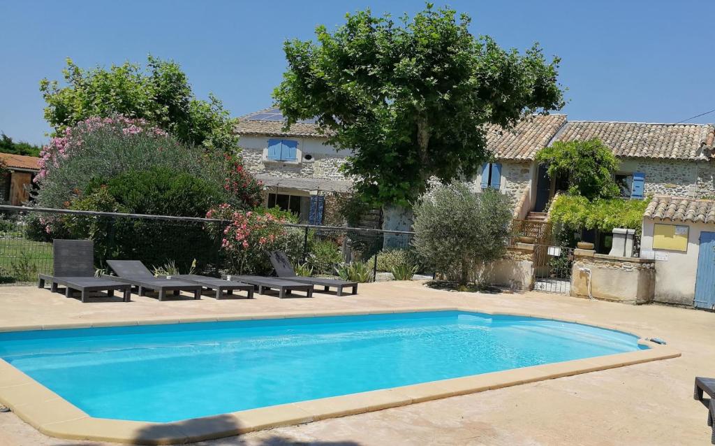 a swimming pool in the yard of a house at Appartements - Le Mas des Oliviers in Richerenches