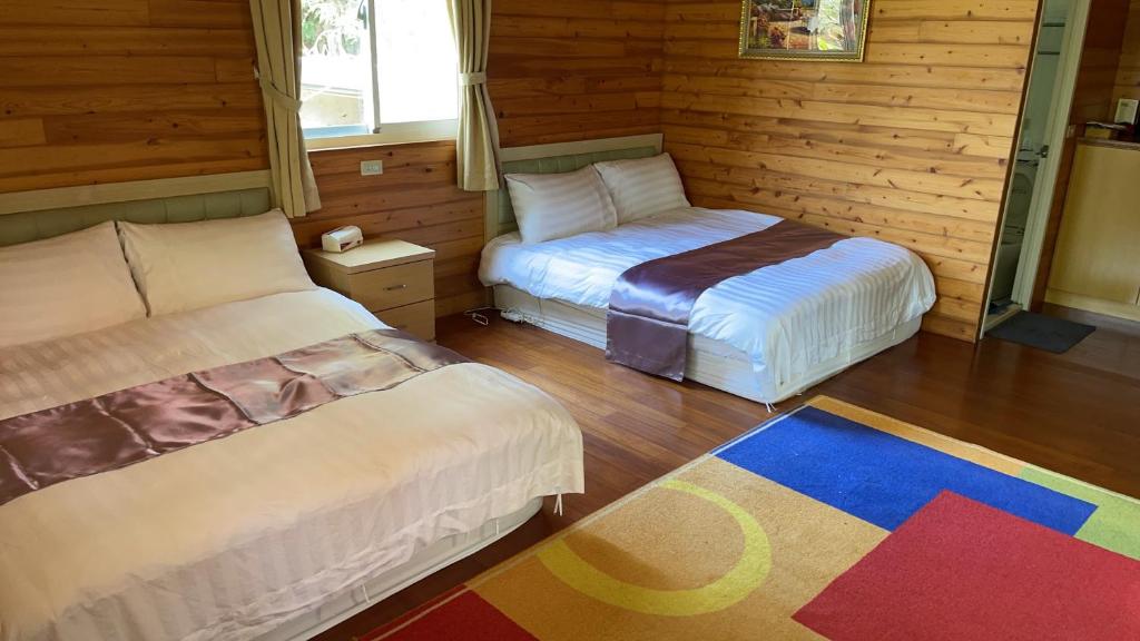 a room with two beds and a colorful rug at 桃山渡假農場 in Fuxing