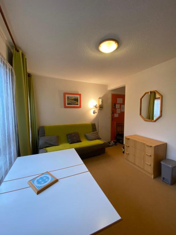 ein Wohnzimmer mit einem Bett und einem Sofa in der Unterkunft Studio au coeur de la Station de Ski in Saint-Aventin