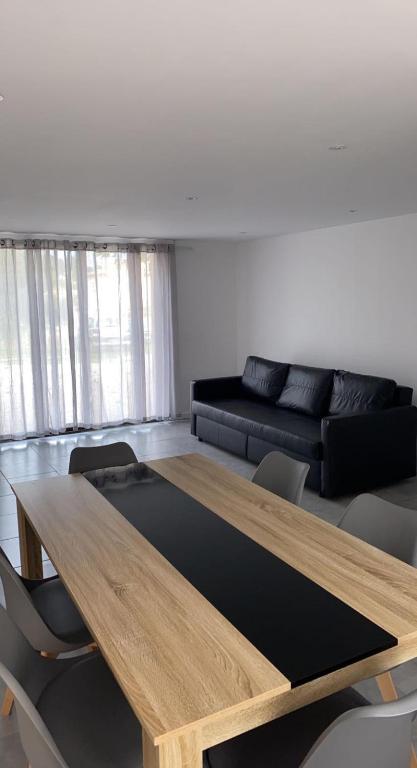 un salon avec une table en bois et un canapé dans l'établissement RDC Villa - Résidentiel - Entrée indépendante, à Marseille