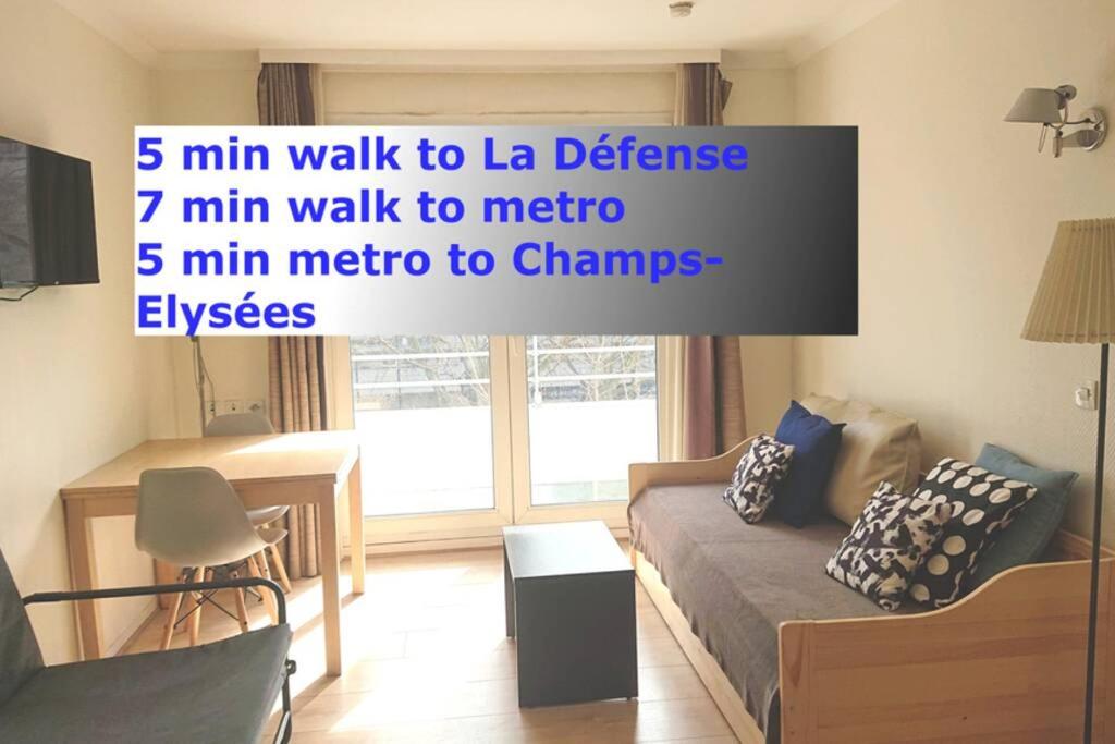 a living room with a couch and a table at 7 min Walk Metro Line 1-La Defense Charras in Courbevoie