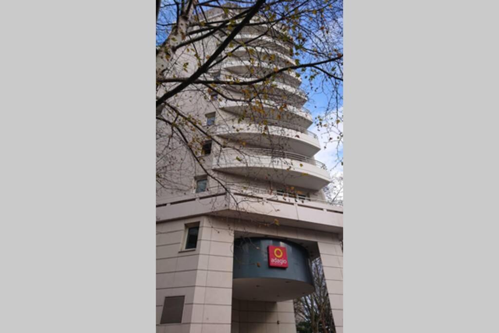 a building with a sign on the side of it at 7 min Walk Metro Line 1-La Defense Charras in Courbevoie