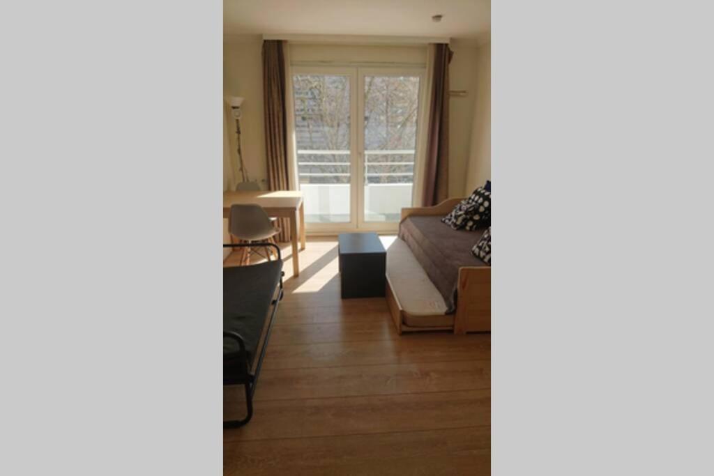a living room with a couch and a window at 7 min Walk Metro Line 1-La Defense Charras in Courbevoie