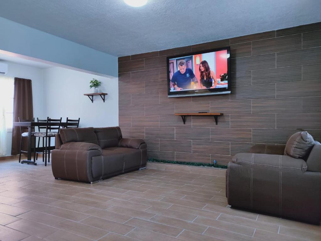 a living room with two couches and a flat screen tv on a wall at 2-bedroom apartment centrally located, near us consulate in Ciudad Juárez