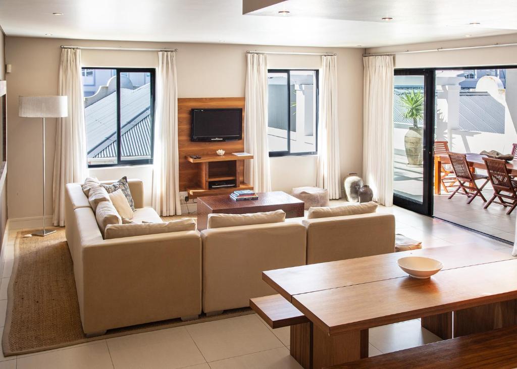 Marine Square Luxury Suites في هيرمانوس: غرفة معيشة مع أريكة وطاولة