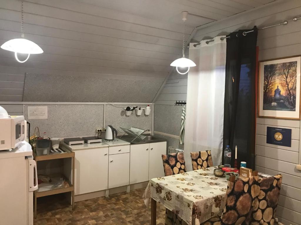 uma cozinha com uma mesa com cadeiras e um micro-ondas em Apartment E-95 em Lozhki